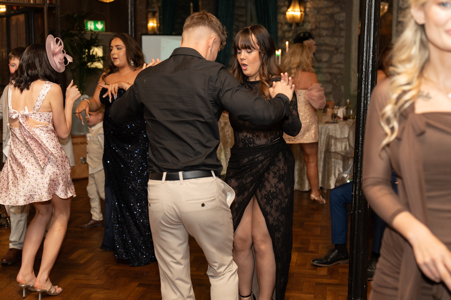 Guests dancing close to the couple on the parquet floor — the first dance flowing naturally into the party